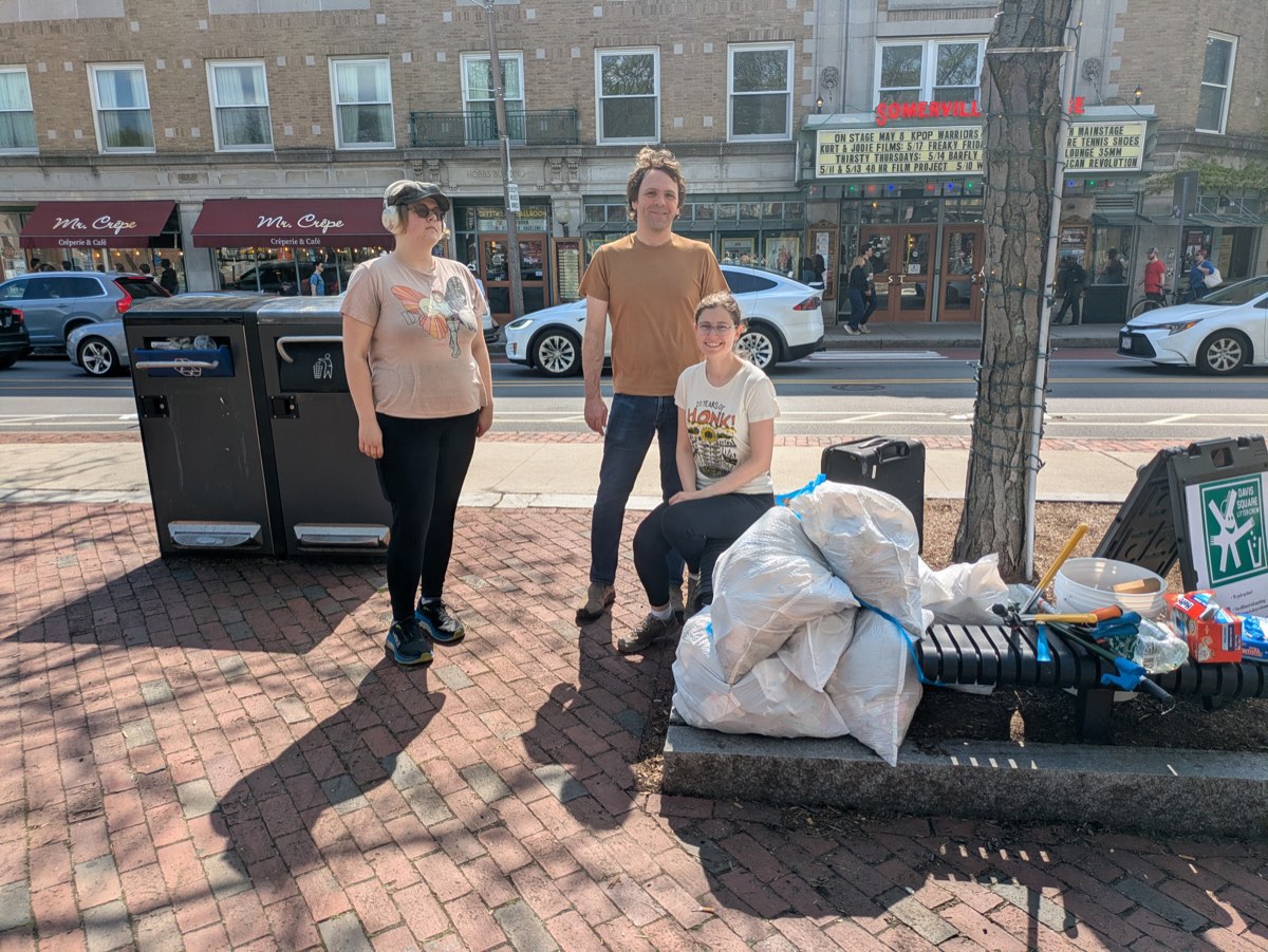 Litter crew volunteers with bags of collected trash in Davis Square, spring