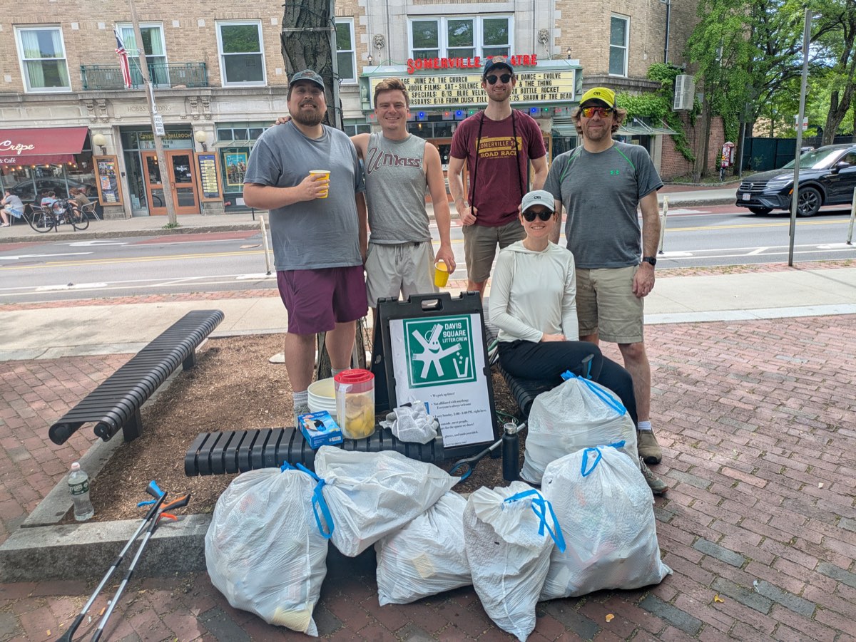 Litter crew volunteers with bags of collected trash in Davis Square, summer
